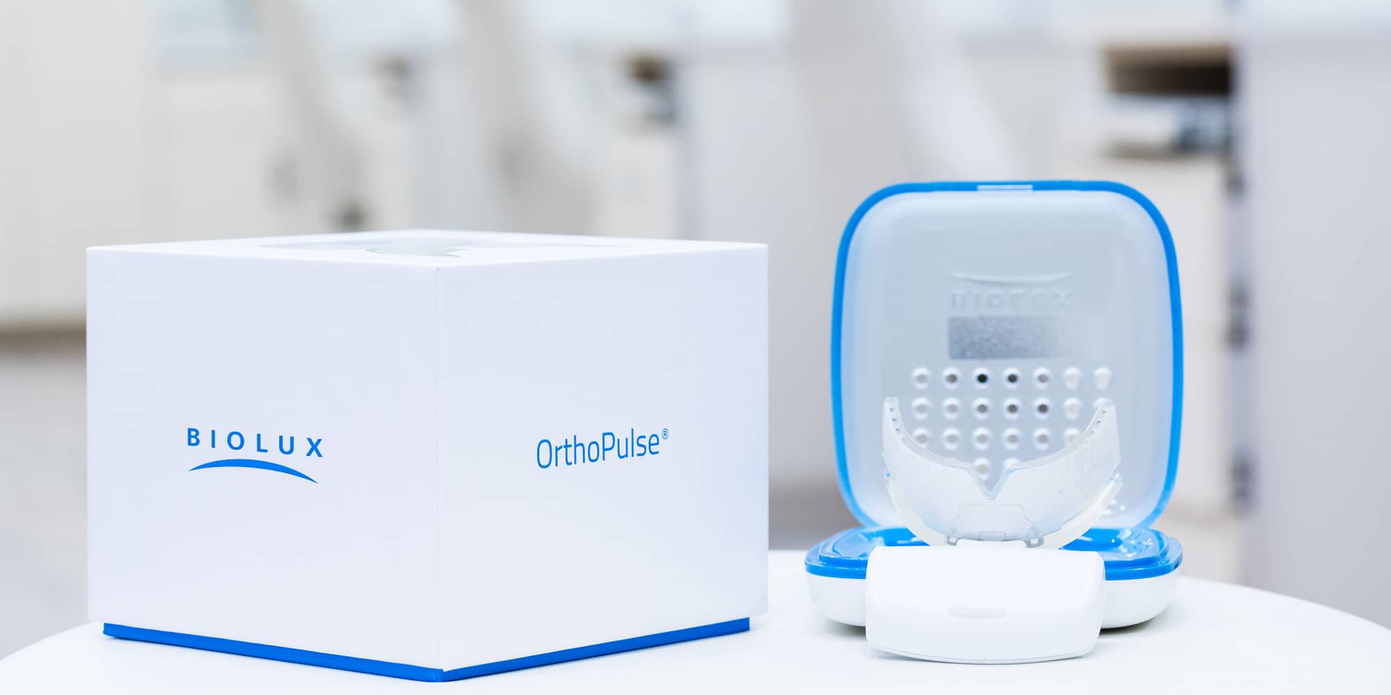 OrthoPulse light-therapy device and its case on a table