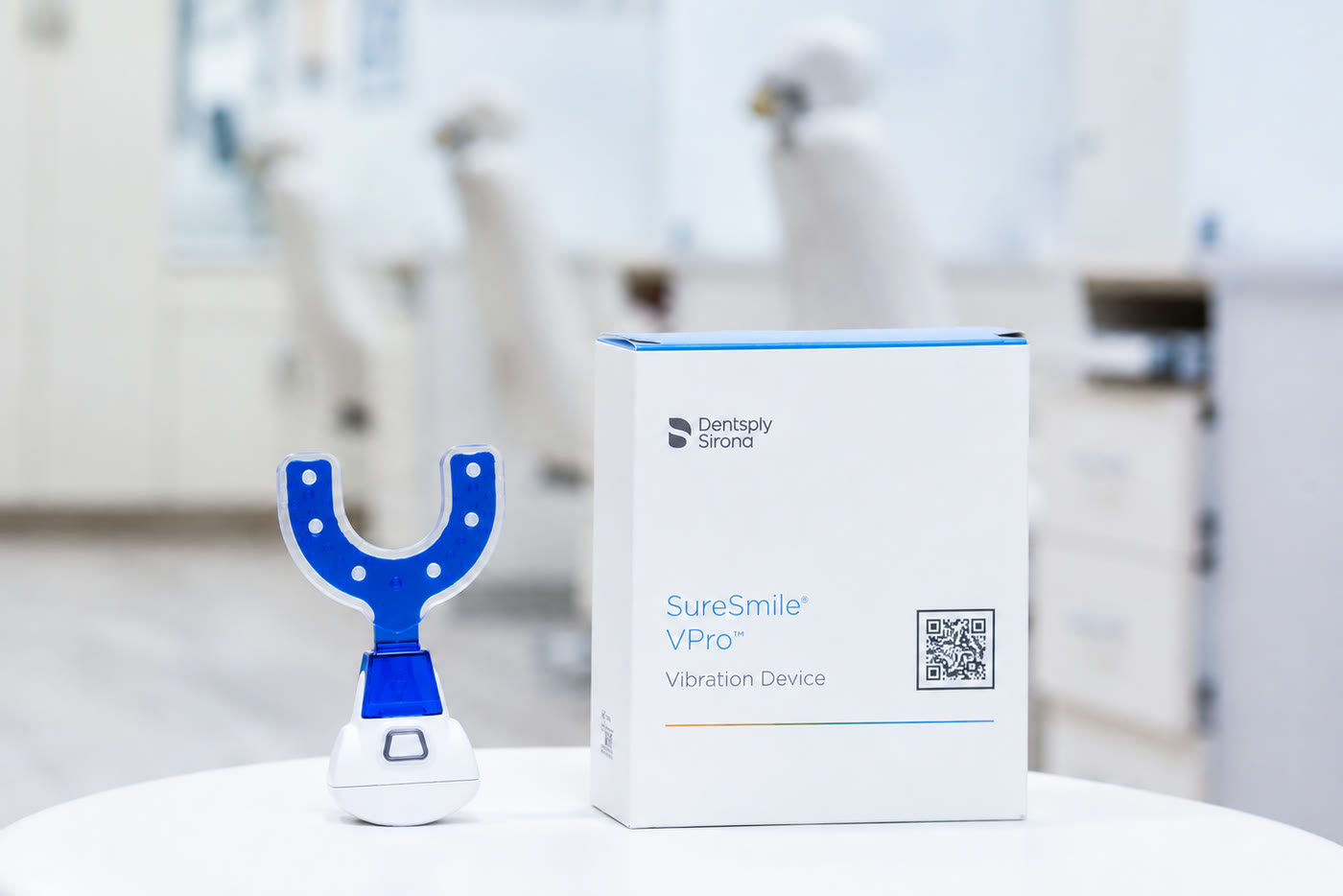 A VPro mouthpiece on its charging base beside its box