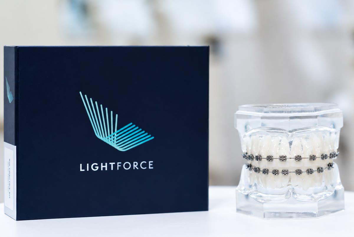 A LightForce box beside a dental model fitted with custom-printed brackets