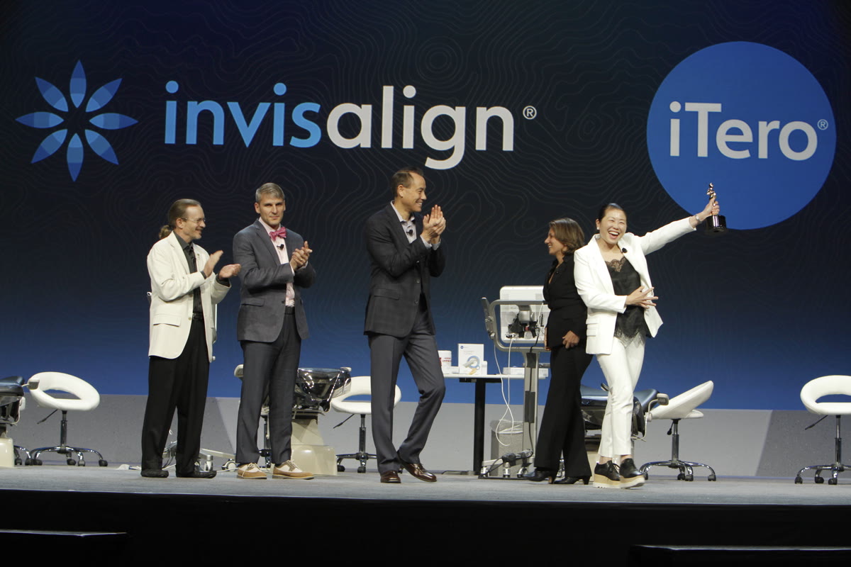 Dr. Bella Shen Garnett receiving an award on stage at an Invisalign summit