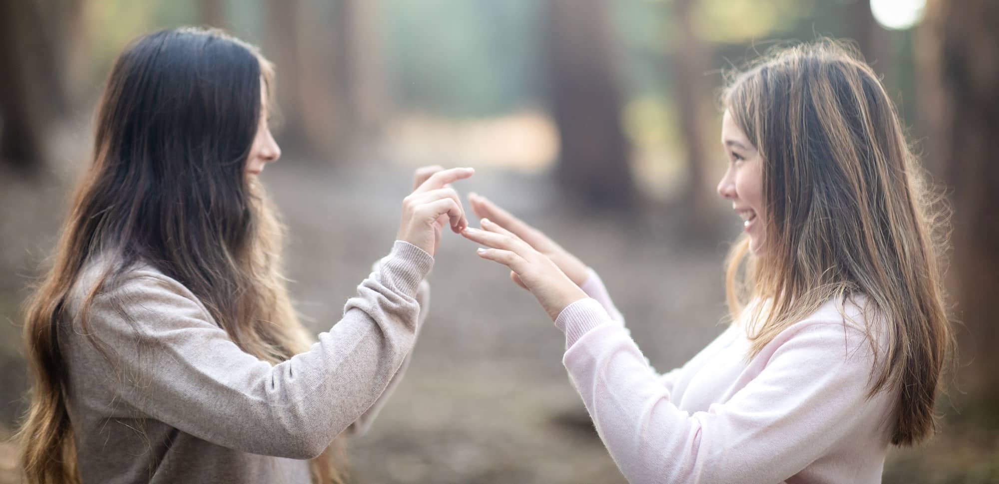 Two teenage girls laughing together outdoors