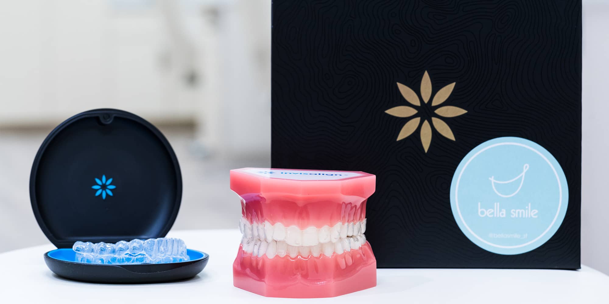 Invisalign aligners in their case beside a dental model