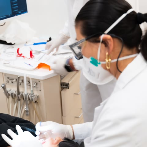An orthodontist checking a patient’s teeth in the treatment chair